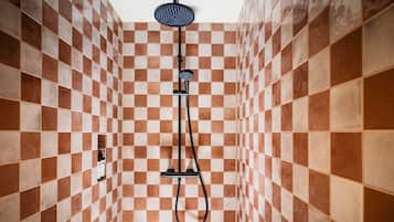 A shower with a checkered tile pattern on the walls.