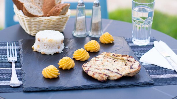 A meal with rice, grilled meat, and pastries on a slate board, accompanied by bread, salt and pepper shakers, and a glass of water. - Hotel ibis Oujda (Oujda)