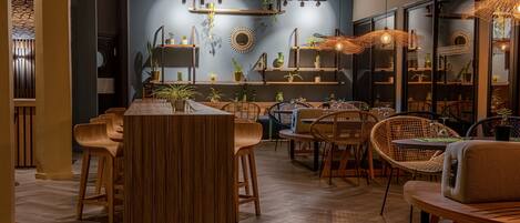 Un comedor moderno con mobiliario de madera, una mesa central y estanterías con plantas.