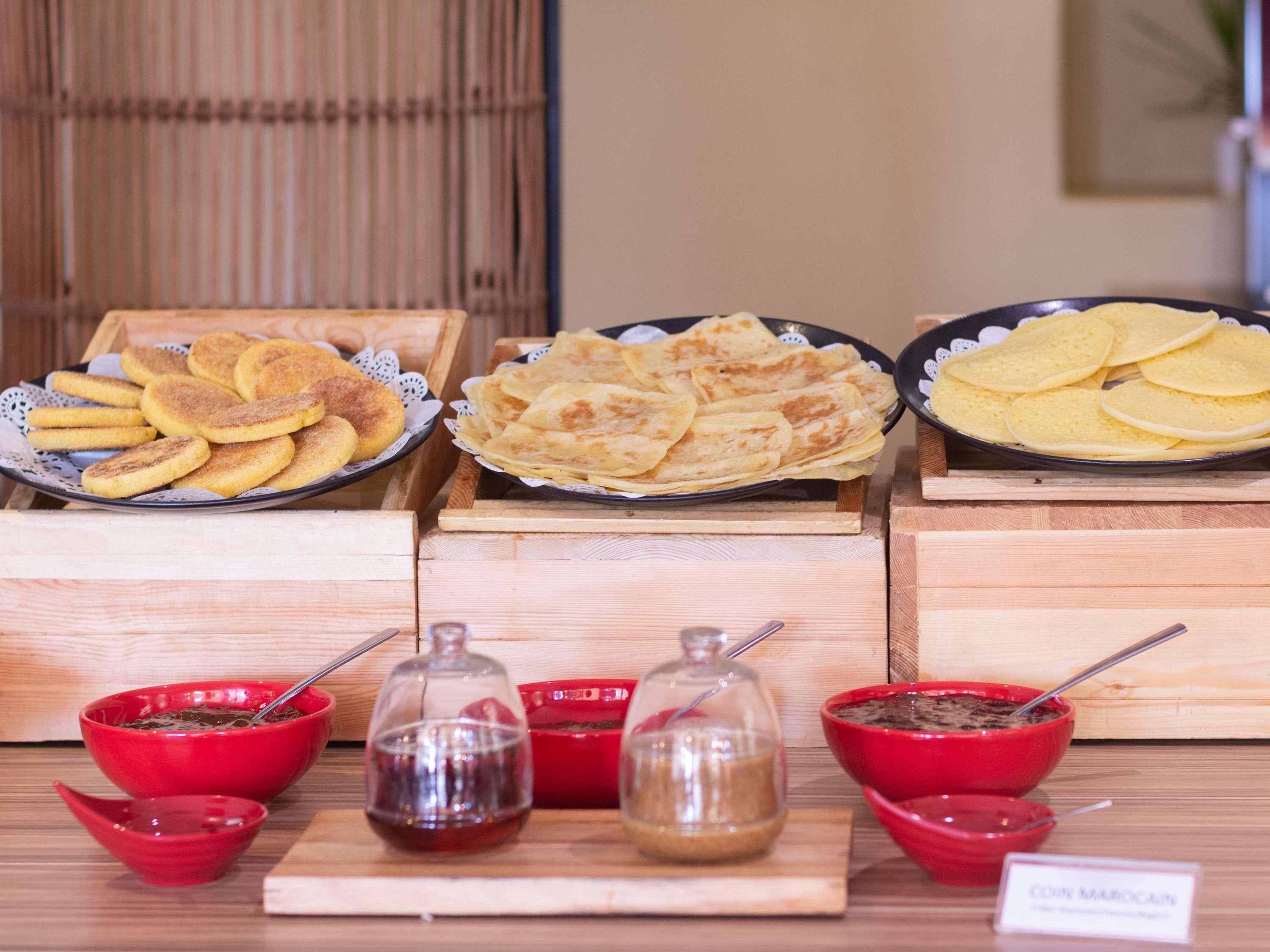 A food display with various baked goods and condiments.