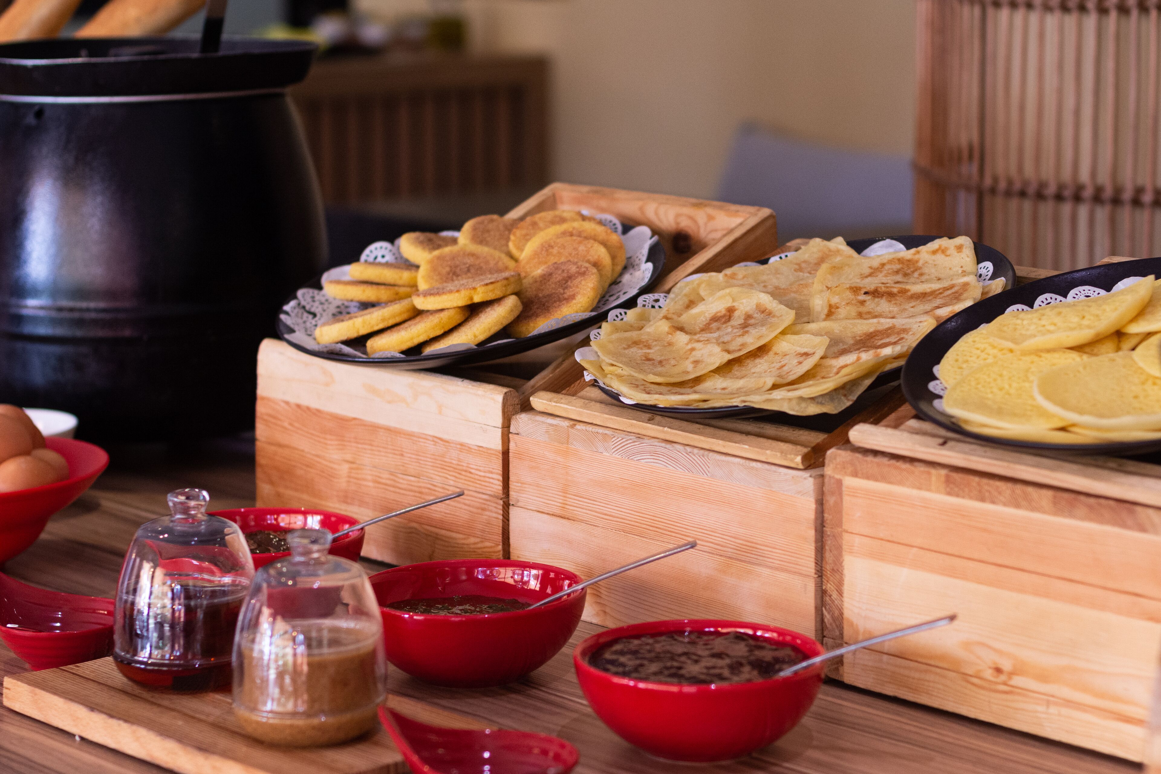 A buffet table with various food items and condiments.