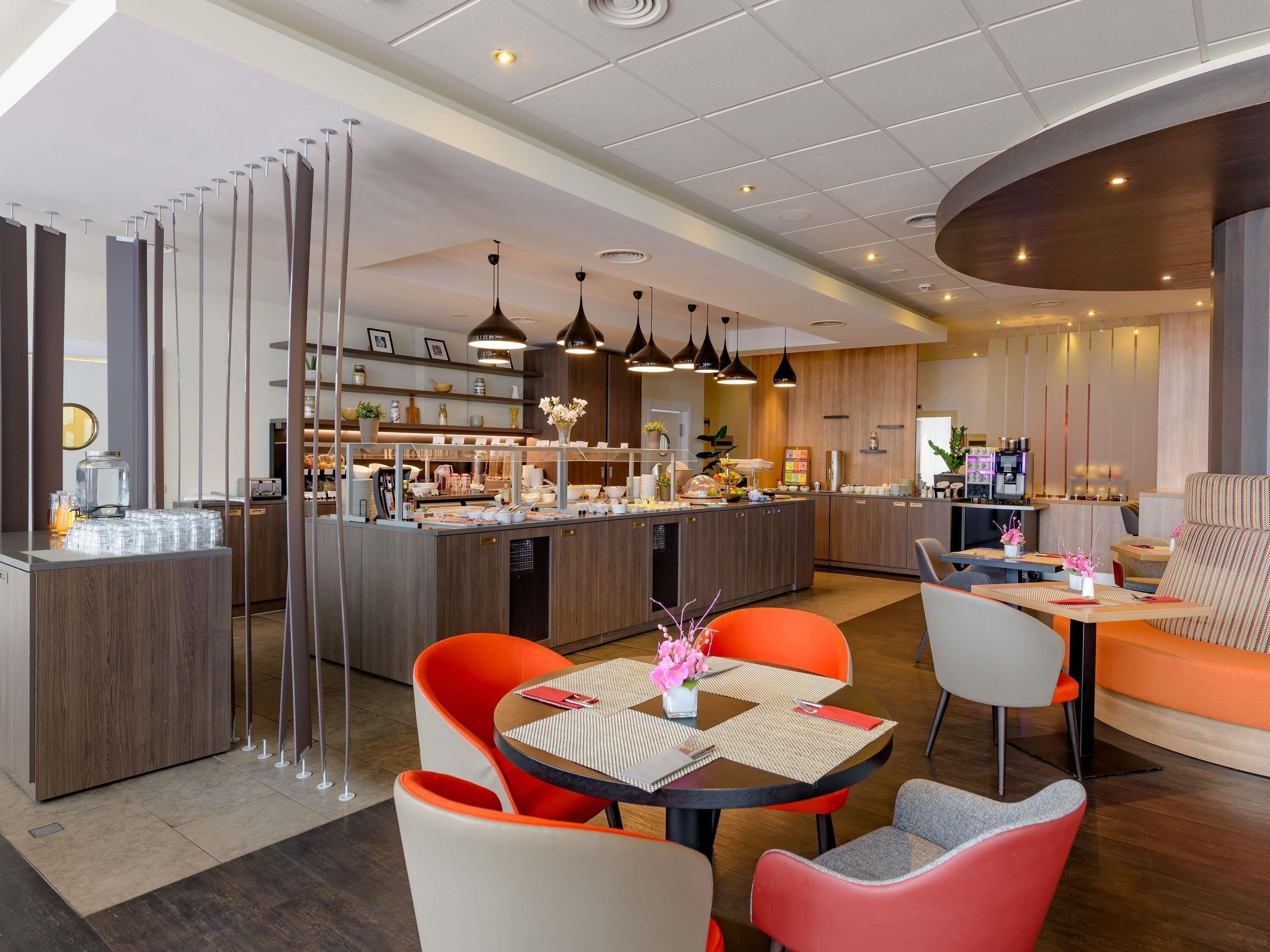 A modern hotel lobby with a central island, seating area, and a coffee station.