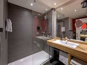 Une salle de bain moderne avec un grand miroir, une baignoire et un meuble-lavabo.