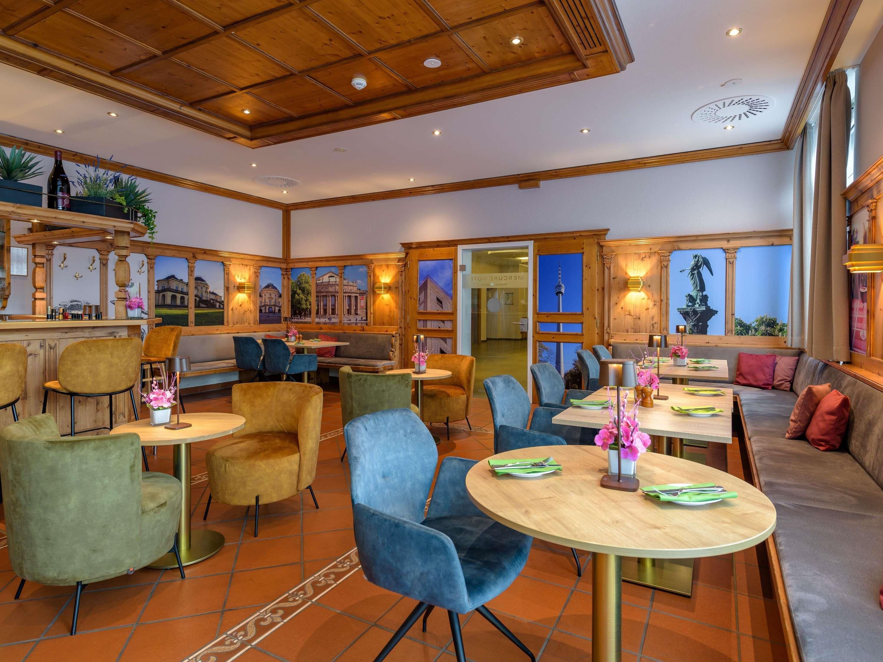 Un restaurante con techo de madera, varias zonas de estar y ventanas amplias.