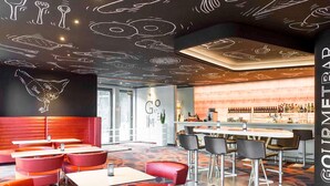 Un espace bar moderne, doté d’un comptoir et de sièges.