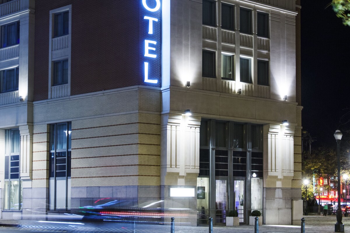 A hotel with a prominent 'NOVOTEL' sign on the facade, large windows, and a modern architectural design.
