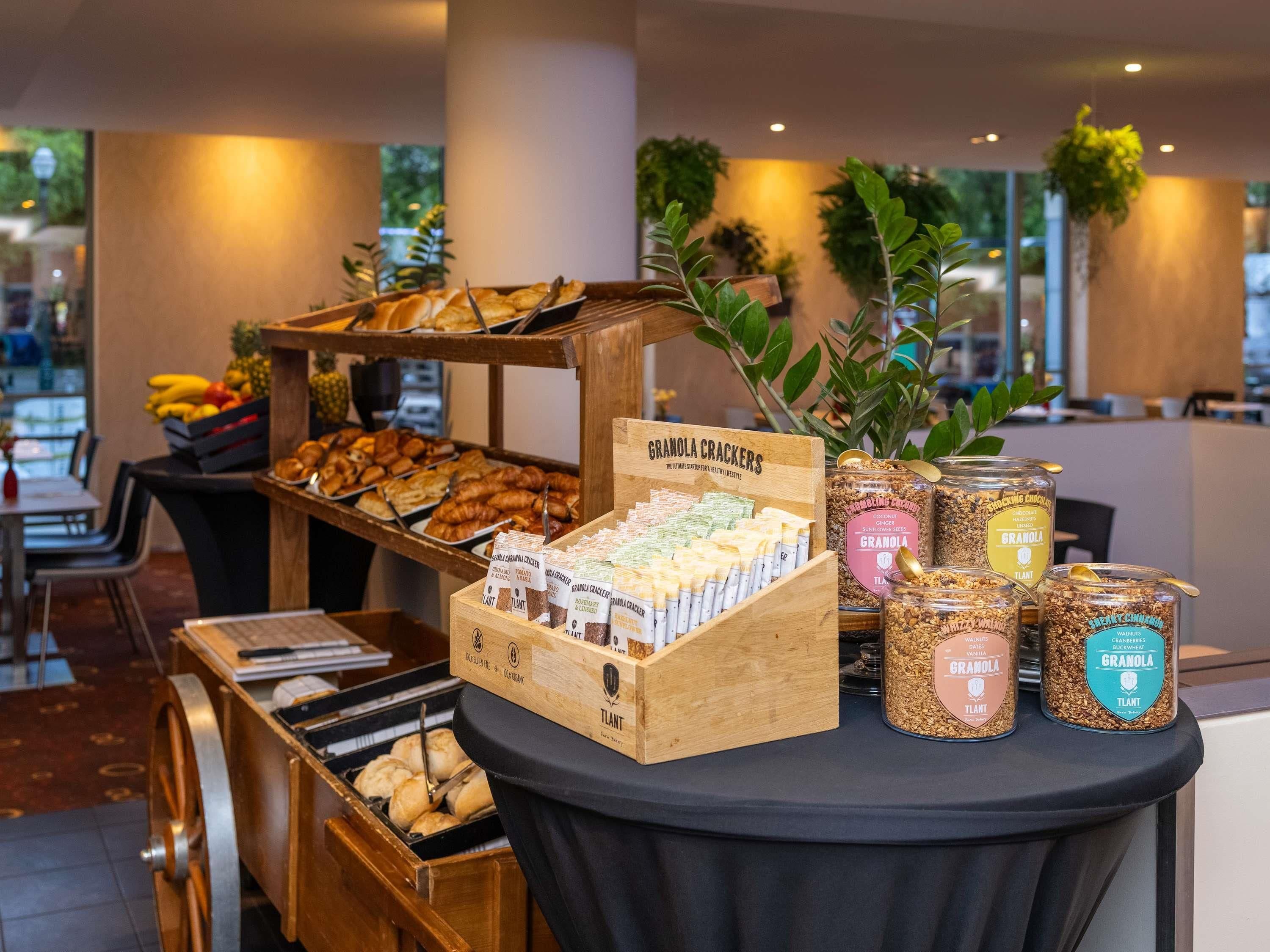 A buffet with granola crackers, various pastries, and jars of granola.