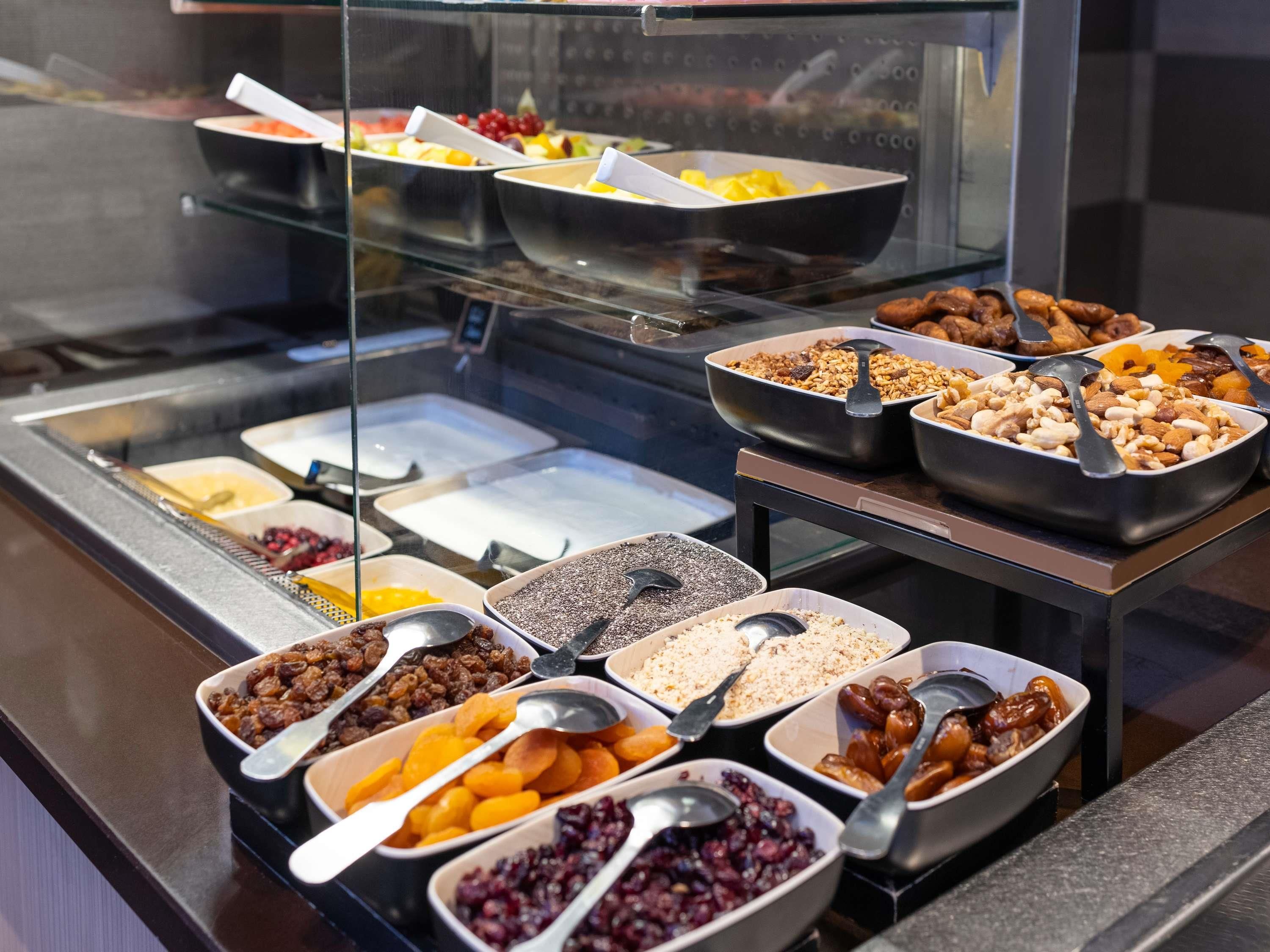 A buffet with various food items including fruits, nuts, and cereals.