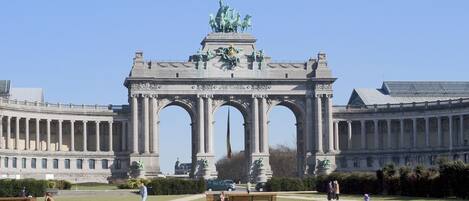 Un edificio grande de estilo clásico con un arco central y estatuas.