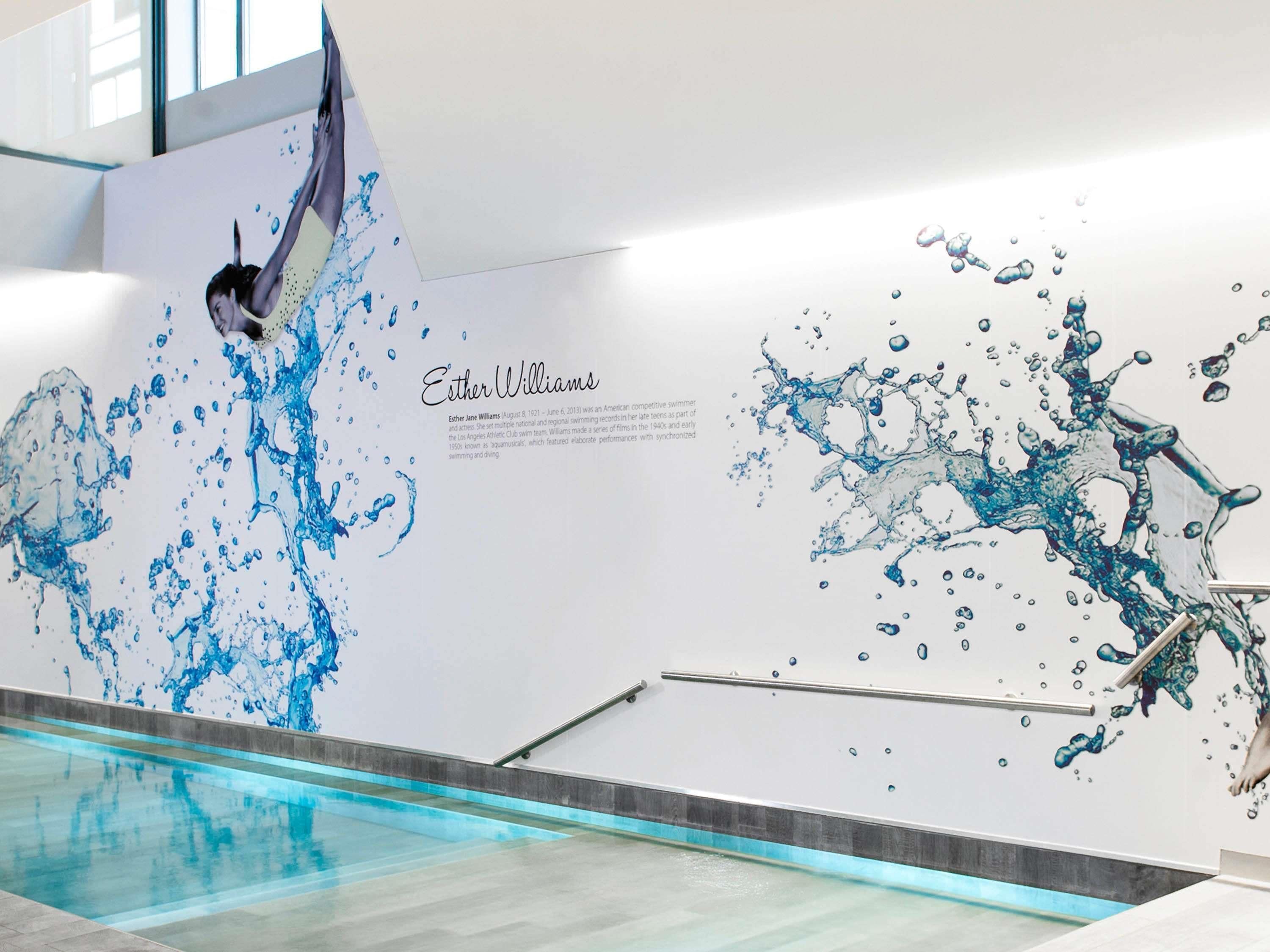 A swimming pool with a mural of a swimmer and water splashes.