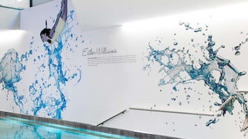 A swimming pool with a mural of a swimmer and water splashes.