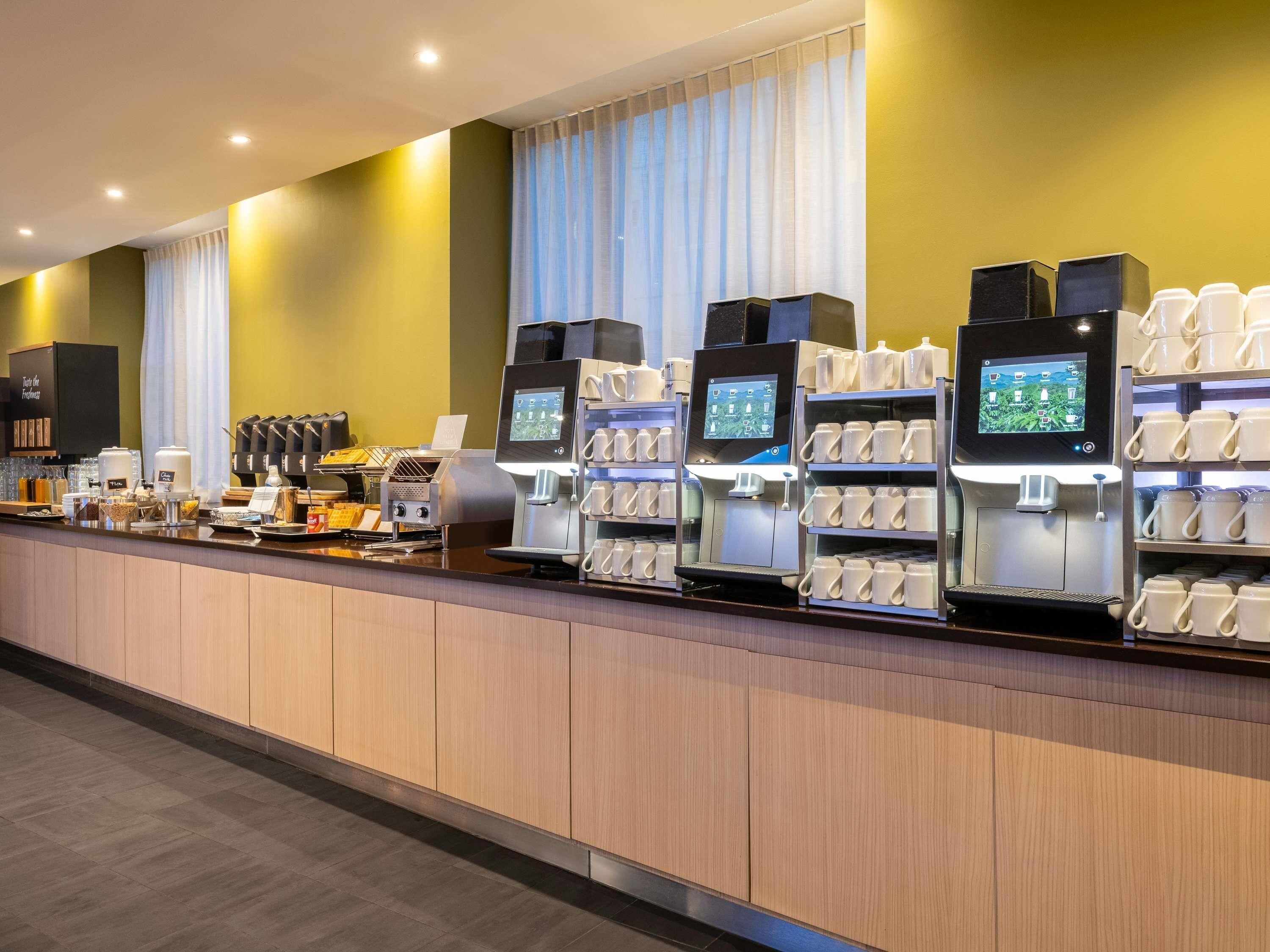 Uma estação de café moderna com várias máquinas de café e um visor digital.