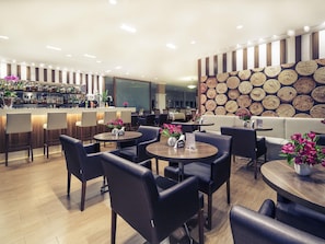 A modern restaurant with a bar area, round tables, and booths. - Mercure Sao Paulo Vila Olimpia (São Paulo)