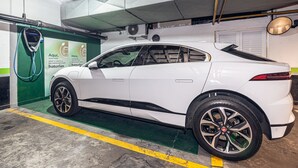 Un coche blanco aparcado en un garaje con una estación de carga.