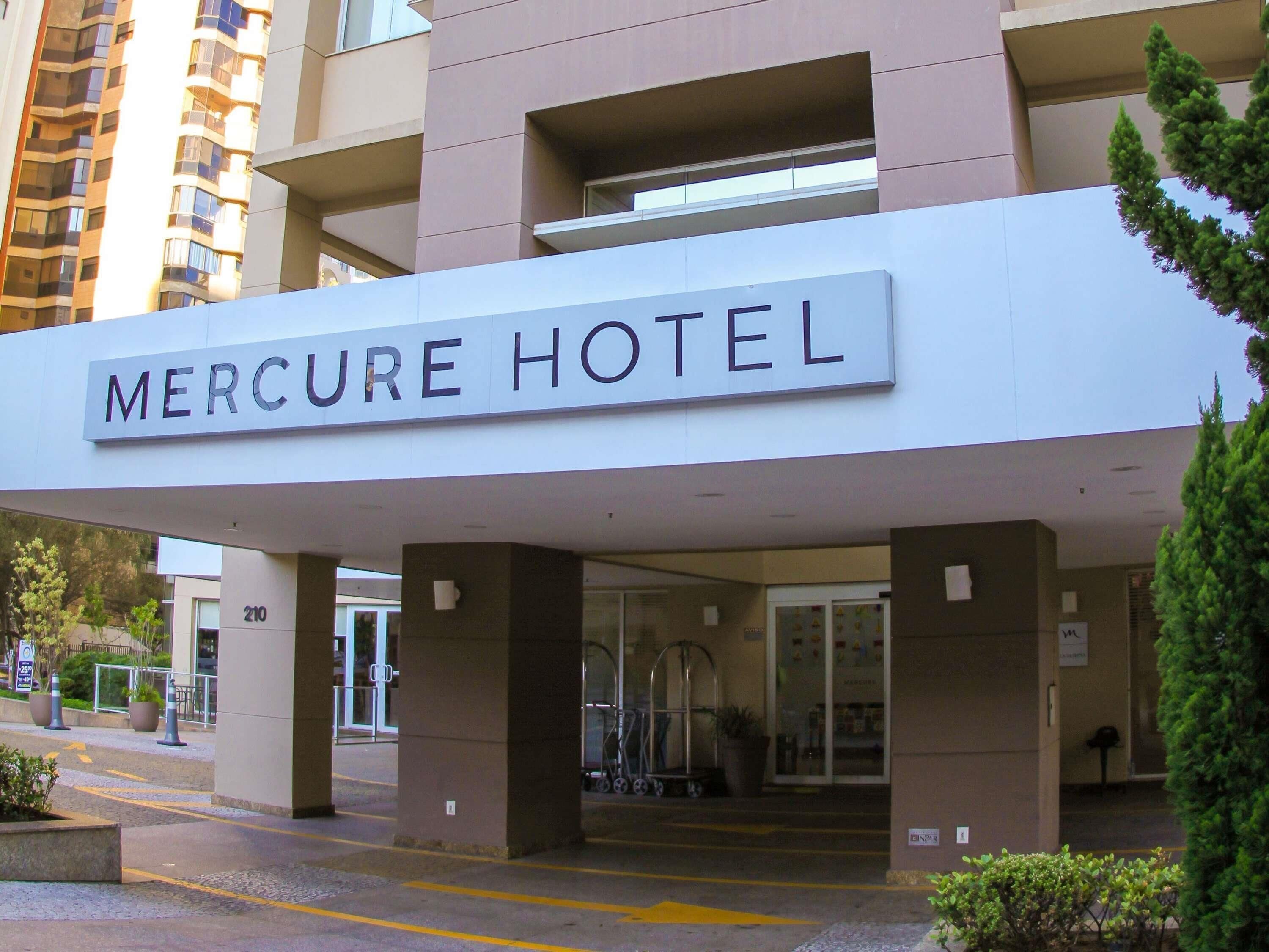 Het exterieur van het Mercure Hotel, met een opvallende ingang en een bord boven de deur.