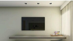 A modern living room with a flat-screen TV mounted on the wall, a built-in bench, and a small black cabinet. - Mercure Sao Paulo Vila Olimpia (São Paulo)