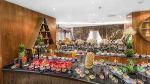A buffet with various food items and drinks, arranged on multiple tables.