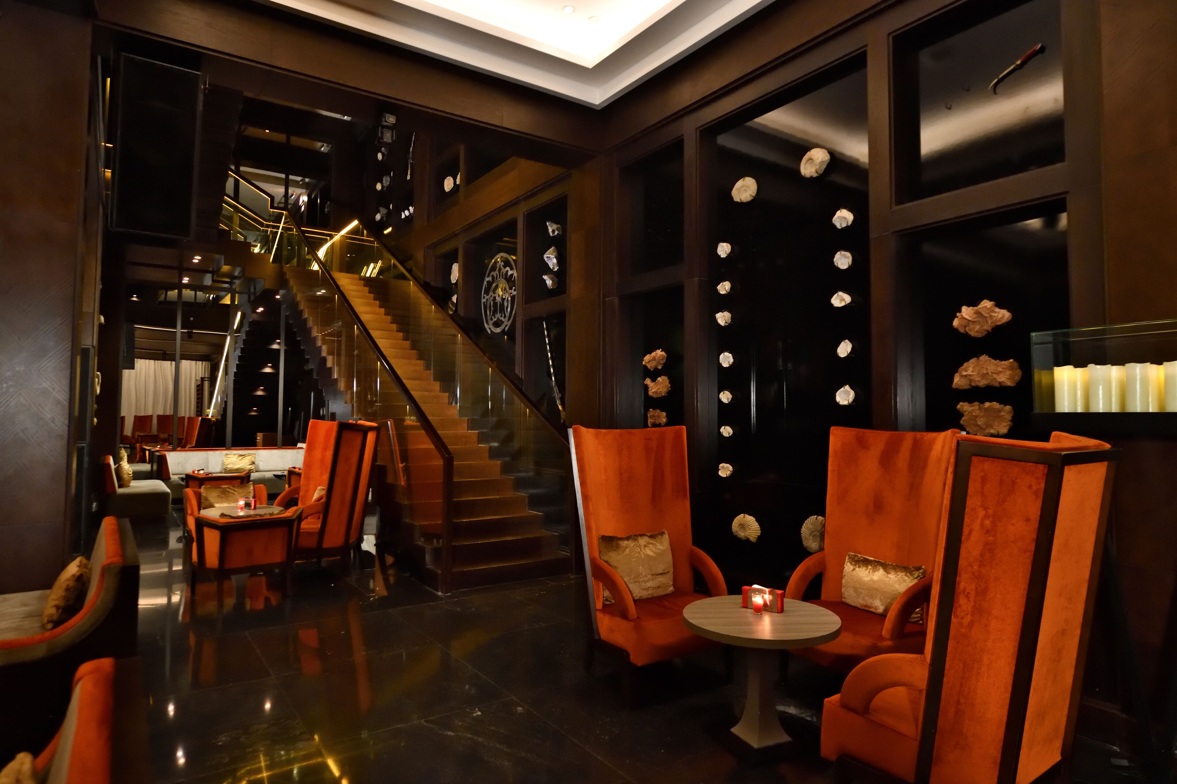 Eine moderne Hotelhalle mit Treppe, Sitzgelegenheiten und Dekorationselementen.