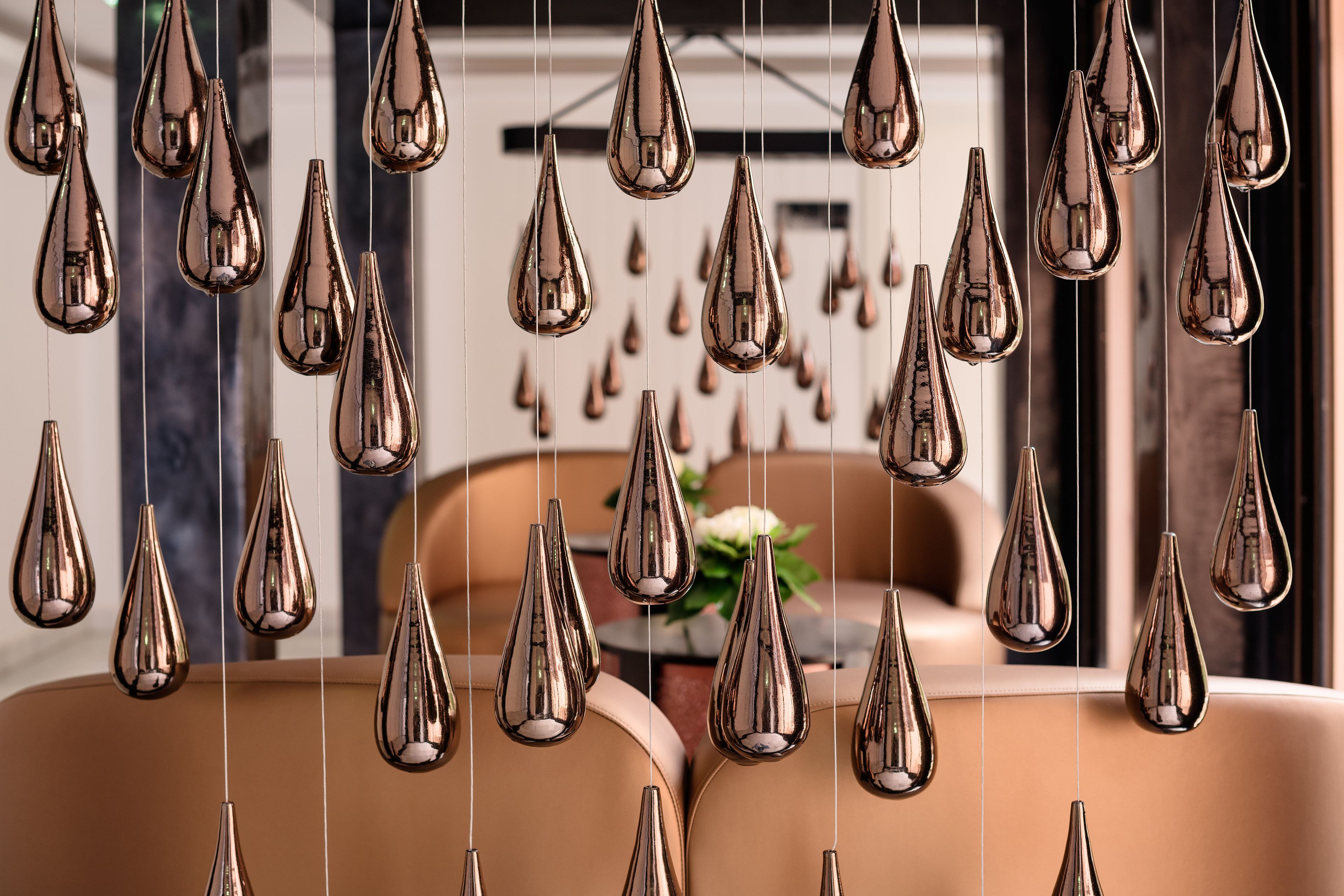 A room with multiple hanging light fixtures and a sofa.