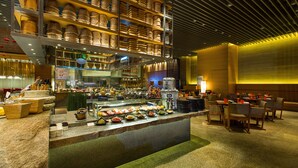 Un área de bufé con diferentes opciones de comida y un espacio de comedor con mesas y sillas.