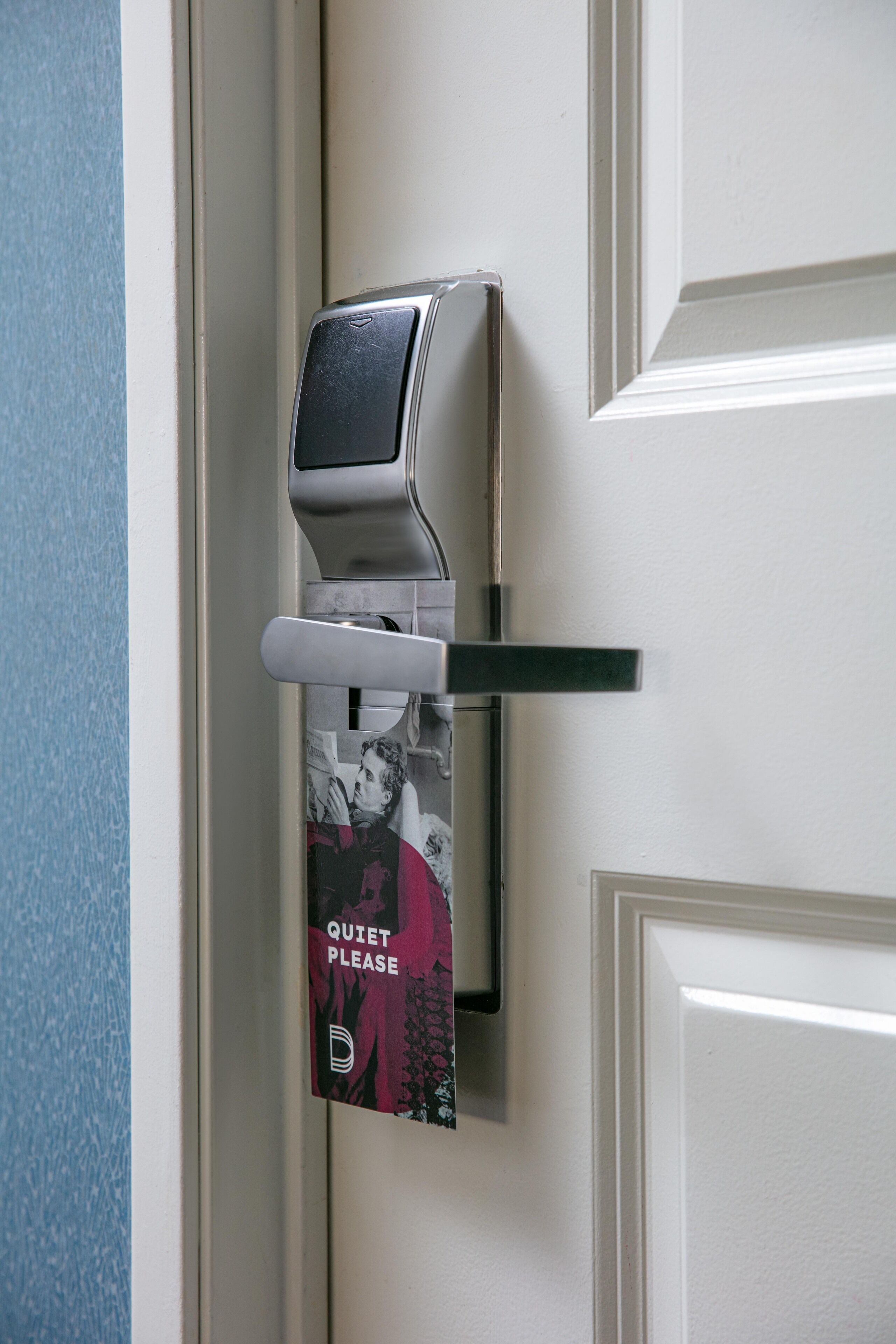 Una puerta con un timbre y un letrero que dice 'Silencio, por favor'.