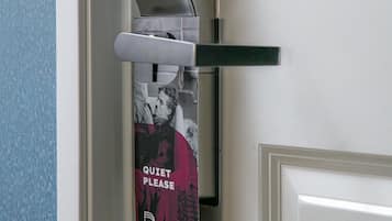 Una puerta con un timbre y un letrero que dice 'Silencio, por favor'.