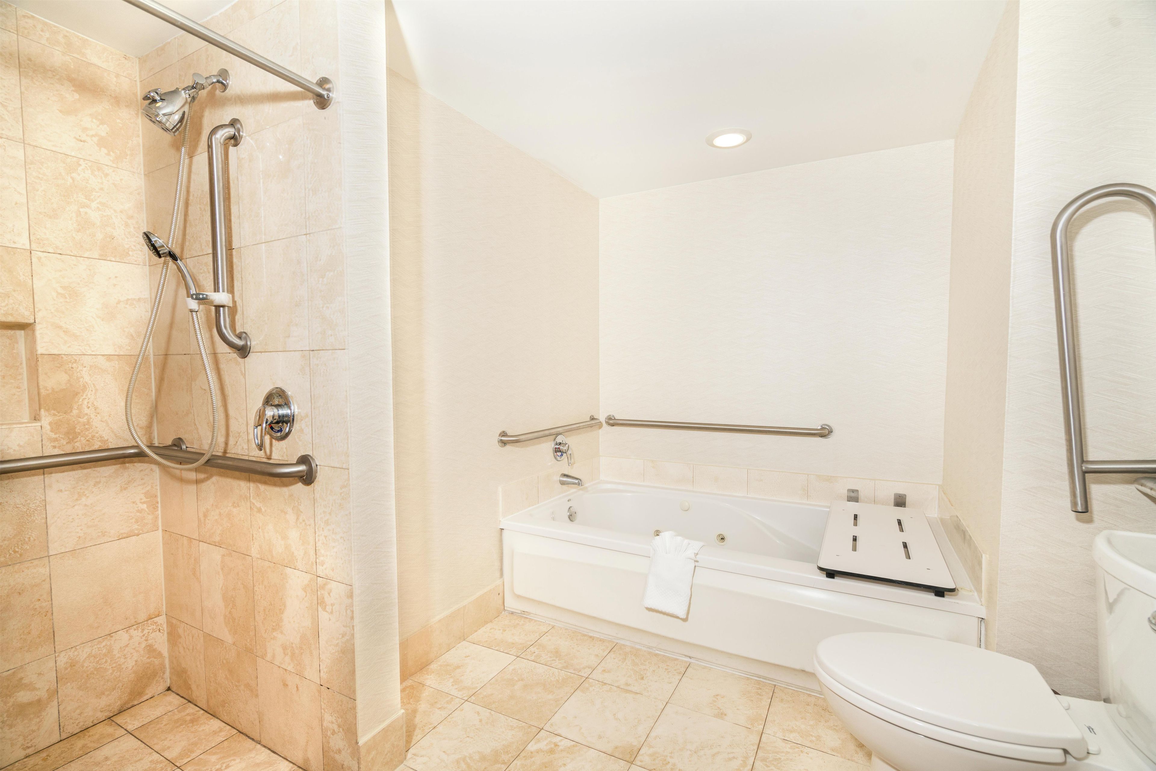 Een badkamer met een douche, bad en toilet.