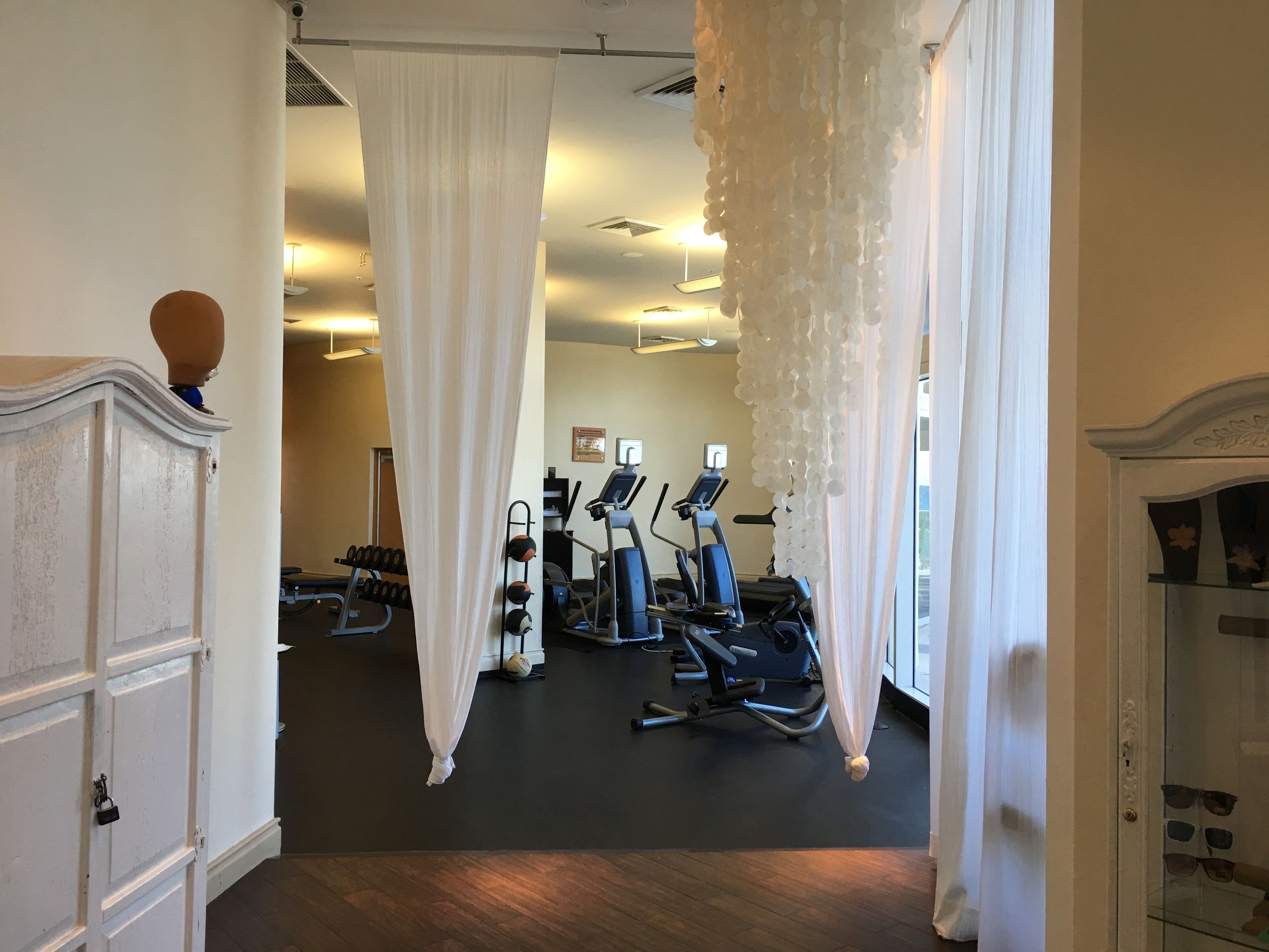 Une salle de sport équipée de matériel d’exercice, d’un miroir et d’une porte dotée d’une poignée décorative.