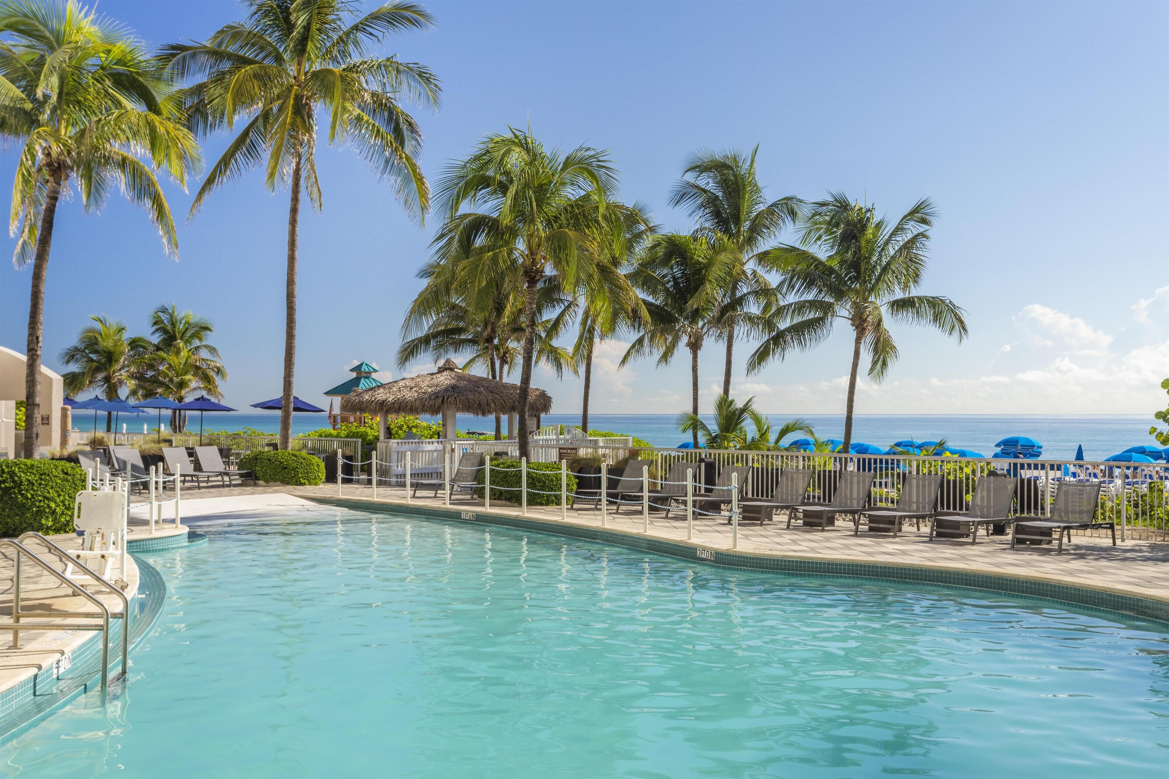 Piscine extérieure, parasols de plage, chaises longues