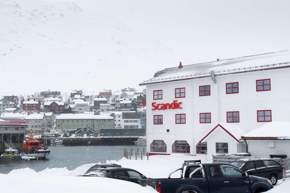 Une vue hivernale d’un quai enneigé, avec un bâtiment portant l’inscription « Scandic ».