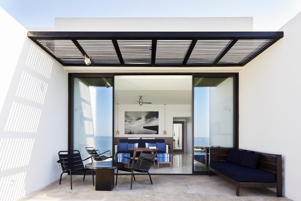 An open-plan living area with a glass wall, a dining table, and seating.