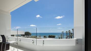 Ein Balkon mit freiem Blick auf das Meer und Palmen.