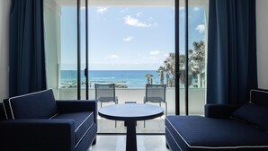 Un balcon avec vue sur l’océan, deux canapés et une petite table.