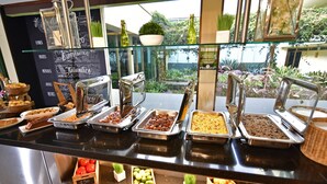 Ein reichhaltiges Buffet mit verschiedenen Speisen und Blick auf den Garten.