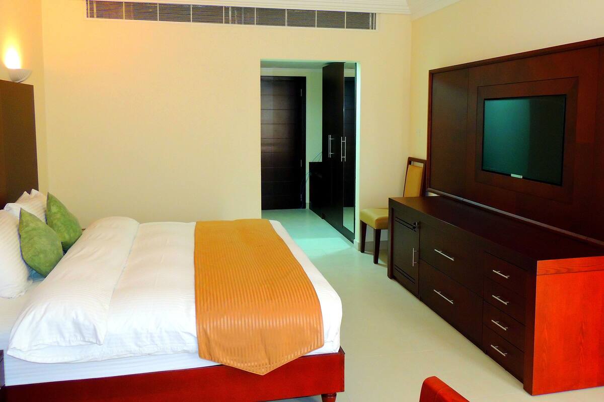Minibar, escritorio, cortinas blackout y tabla de planchar con plancha