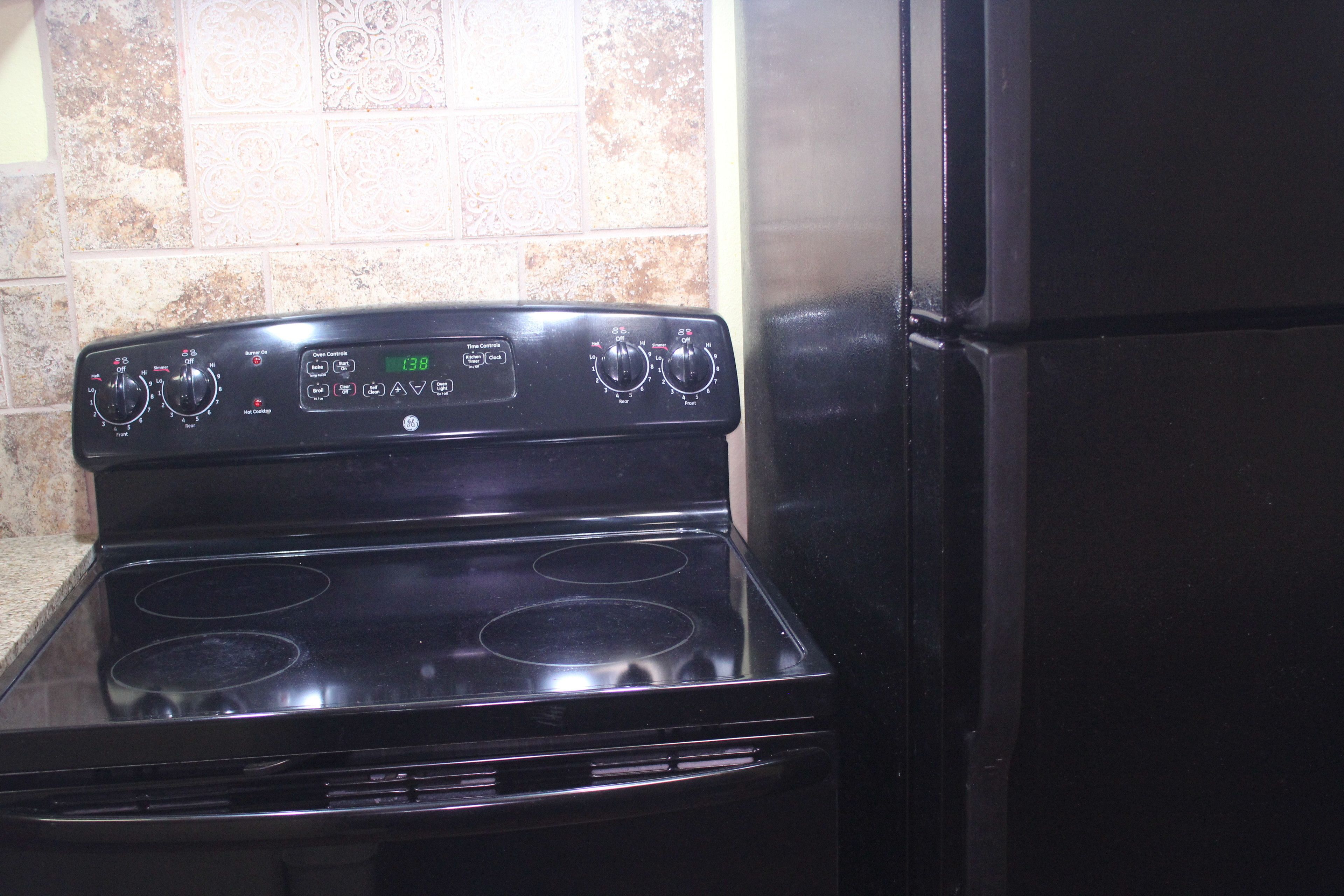 A black stove with four burners and a digital control panel.