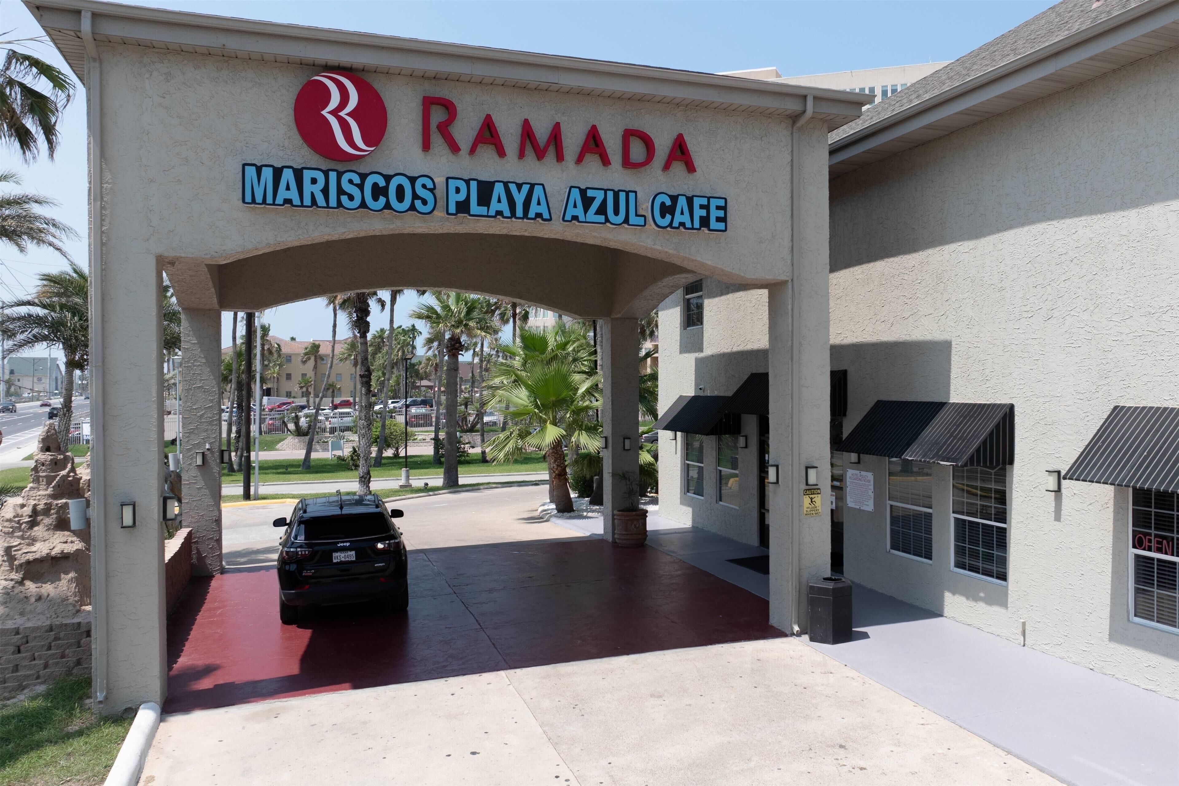 En byggnadsingång med en skylt för Ramada Mariscos Playa Azul Café.