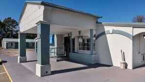 Un bâtiment doté d’une entrée abritée, d’une poubelle et surplombant un ciel dégagé.