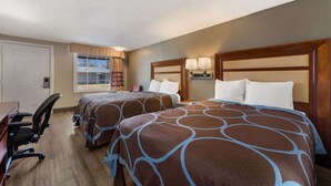 Une chambre d’hôtel avec deux lits, un bureau et une chaise.