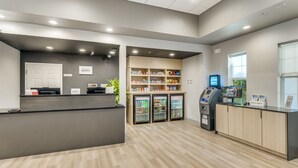 A reception area with a counter, a refrigerator, an ATM, and a sign for Bonvoy.