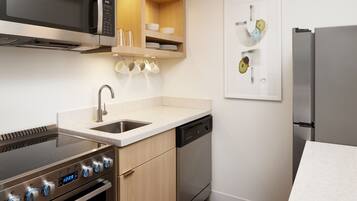 A modern kitchen with stainless steel appliances, a dishwasher, and a microwave.