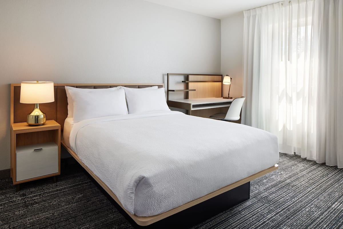 Roupas de cama premium, escrivaninha, espaço de trabalho para notebook