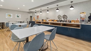 Un restaurante moderno con mostrador, sillas y mesas.