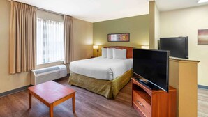 A hotel room with a bed, a TV, a small table, and a heater. - Extended Stay America Suites - Norfolk - Virginia Beach (Virginia Beach)