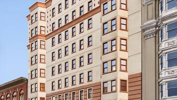 A multi-story hotel with a classic architectural design, featuring a curved facade and multiple windows.