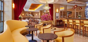 A hotel lobby with yellow seating, a bar area, and a large mirror on the wall. - Orchard Hotel (San Francisco)