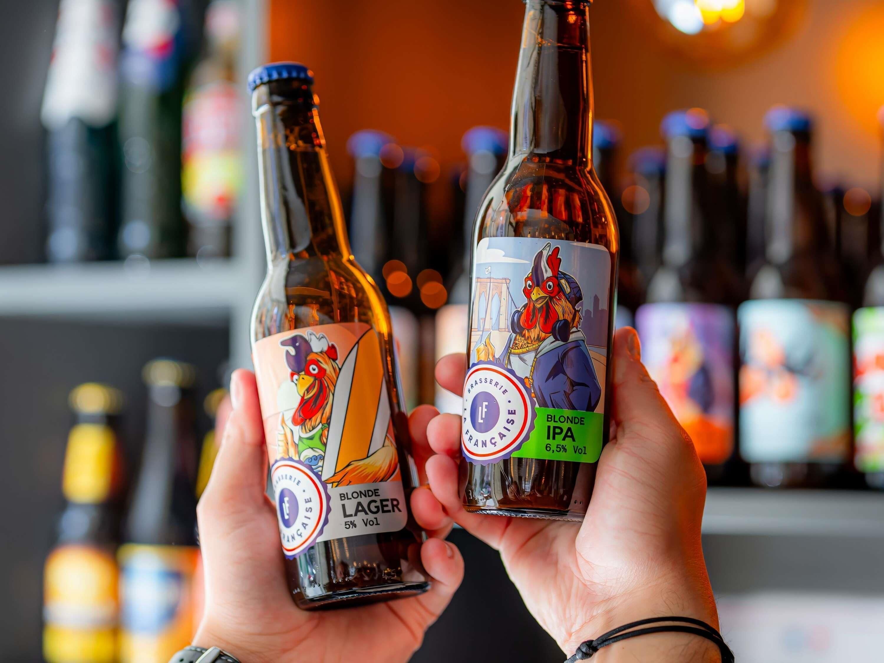 Una persona sostiene dos botellas: una de Blonde Lager y otra de Blonde IPA.