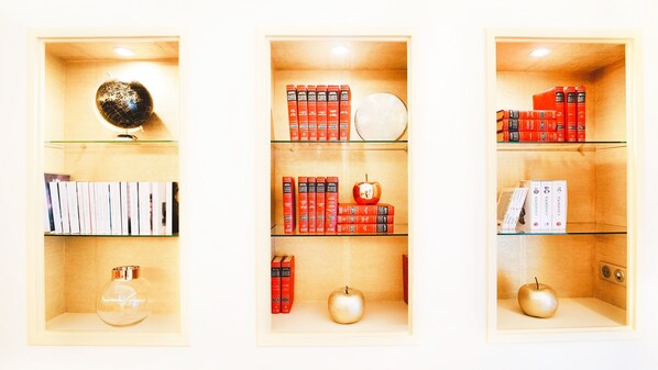 Tres estantes con libros, un globo terráqueo y objetos decorativos.