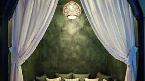 A cozy bed with a canopy, a bedside table with a bottle and glasses, and a tray with a bottle and glasses. - Hotel Duquesne Eiffel (Paris)