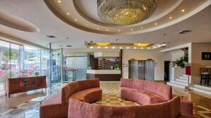 A spacious lobby with a checkered floor, a large chandelier, and a modern reception desk. - Capsis Astoria Heraklion Hotel (Heraklion)